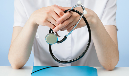 Doctor during a reception of patient, blue backgroundの写真素材