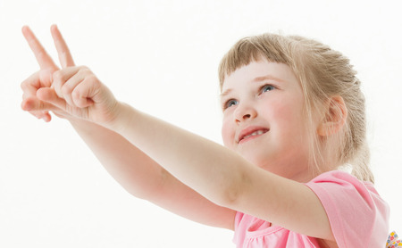 Happy little girl indicating something, white backgroundの写真素材