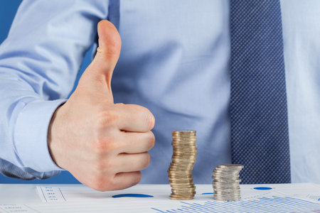 Business man working at the table and showing thumb up sign, closeup shotの写真素材