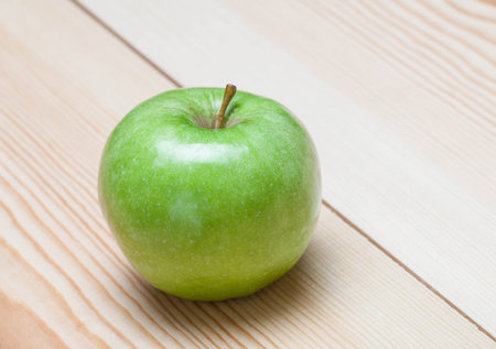 Green apple on wooden background