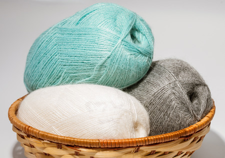 Skeins of yarn in a wooden basket on neutral backgroundの写真素材