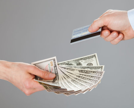 Business people exchanging credit card and money - closeup shot of hands
