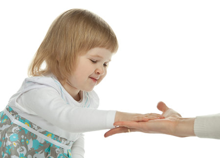 The smiling little girl reaching out her hands to mother; white backgroundの写真素材