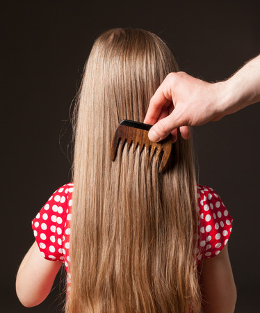 Male hand combing beautiful long hair, closeup shotの写真素材