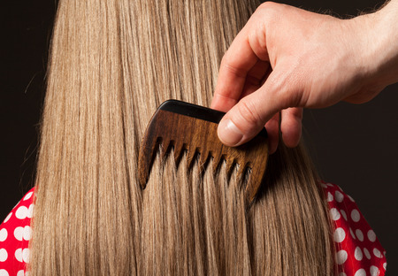 Male hand combing beautiful long hair, closeup shotの写真素材