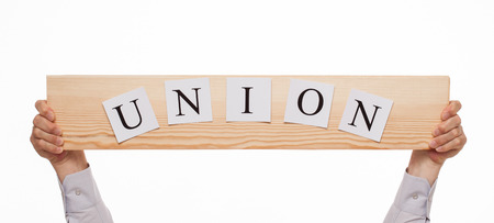 Businessman holding a wooden plate with an inscription "Union", white backgroundの写真素材