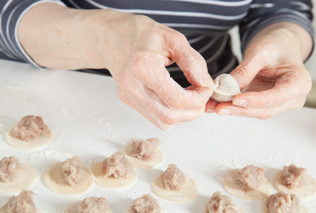 Housewife preparing meat dumplings - closeup shotの写真素材