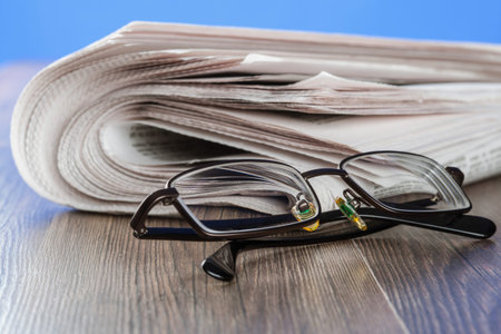 Free newspaper and glasses on the table, closeup shot
