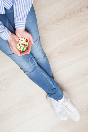 Unrecognizable female hands holding many pills and capsulesの写真素材