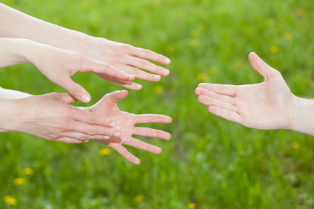People offering help, natural green backgroundの写真素材