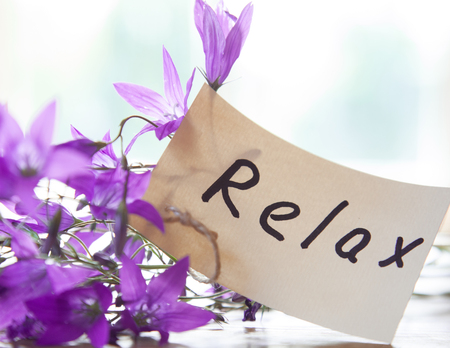 Fresh wildflowers and small paper tag with text "Relax" on white background - spa and relaxation compositionの写真素材
