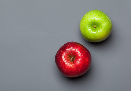 Ripe green and red apple on gray background