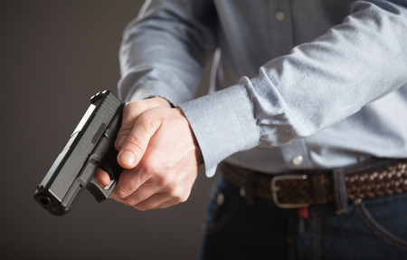 Unrecognizable man with pneumatic gun on dark grey backgroundの写真素材