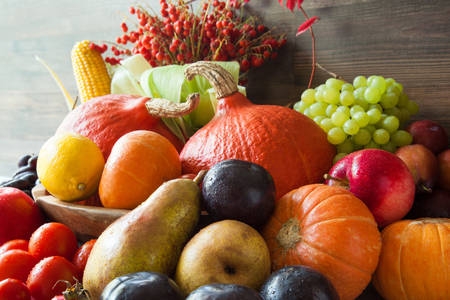 Autumn harvest: plenty of fruits and vegetables on wooden backgroundの写真素材