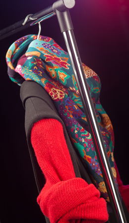 Fashionable woman clothes hanging in a store on black backgroundの写真素材