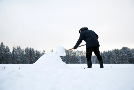 Man removing snow from a driveway after heavy snowfall in countrysideの写真素材