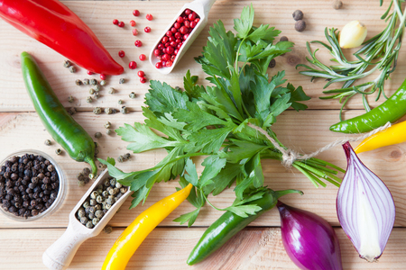Variety of fresh salad ingredients and dry spices on wooden background, upper viewpointの写真素材