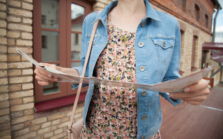 Exploring historical places of a town - unrecognizable young woman tourist with a paper mapの写真素材
