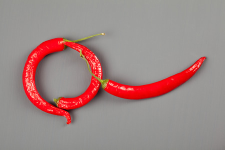 Group of red chili peppers on gray backgroundの写真素材