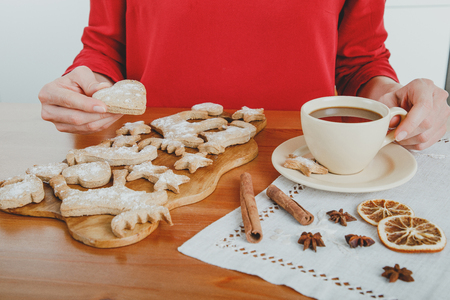 Unrecognizable woman having hot chocolate with ginger cookies for dessertの写真素材
