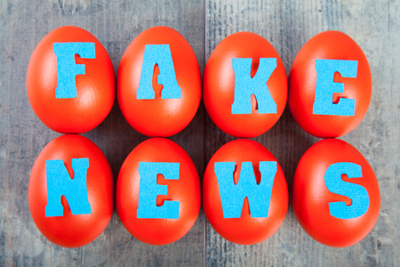 Factory of fake news: eggs with "fake news" words on wooden backgroundの写真素材