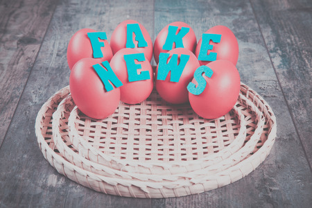 Birth of the fake news: eggs with "fake news" words on wooden backgroundの写真素材