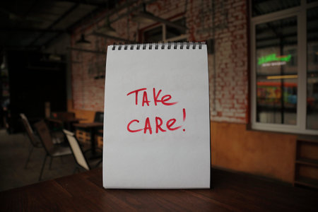 Take care text written on a paper on the empty cafe table