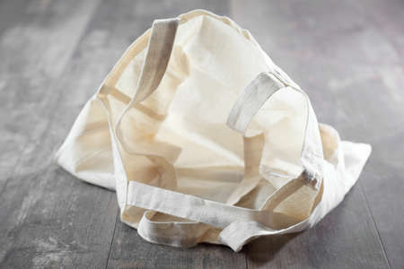 Beige textile eco bag on wooden floorの写真素材