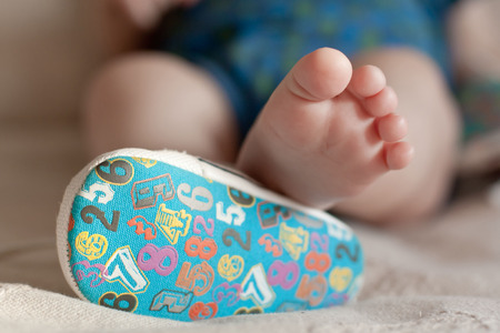 A close-up of tiny baby feet. closeup of adorable title baby shoes の写真素材