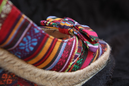 Multicolored female shoes on a black cloth backgroundの写真素材