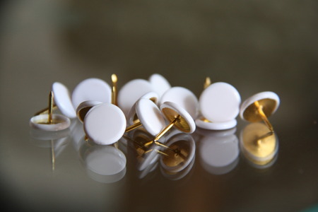 White Push Pins Isolated On mirror tableの写真素材