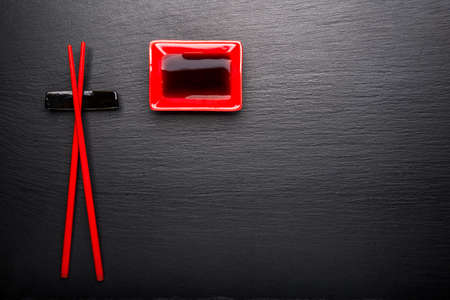 Red chinese set for sushi on a black slateの写真素材