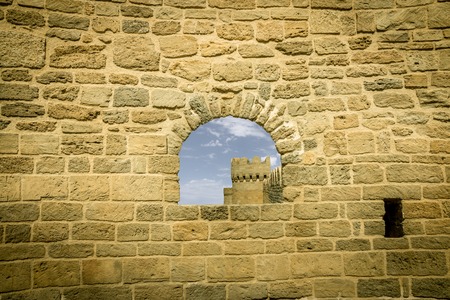 Ancient stone window with castle and sky background. View to outside.の写真素材