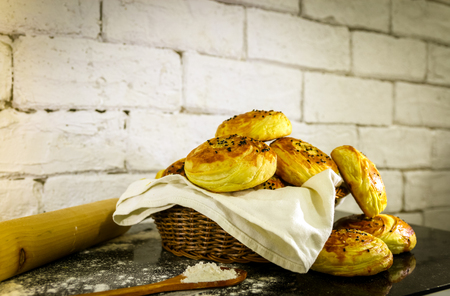 Fresh homemade buns on basket with rustic white brick background. Close up shotの写真素材