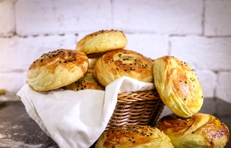 Fresh homemade buns on basket with rustic white brick background. Close up shotの写真素材