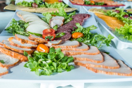 Salad with sausage, greens and other on table with white table. Catering concept.の写真素材