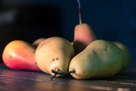 Group of ripe pears on dark rustic wooden table.の写真素材