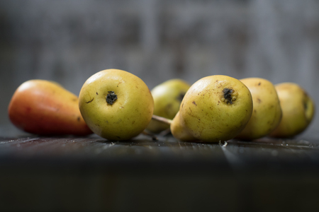 Group of ripe pears on dark rustic wooden table. Side view horizontal shot. Empty copyspace for your design.の写真素材