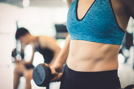 Closeup of young slim woman with six-pack muscles in the gym,Fitness and Healthy Lifstyle Concept.の写真素材