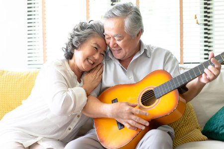 Lovers in a living room.Happy senior woman hugging bearded man in love sitting on the sofa while...