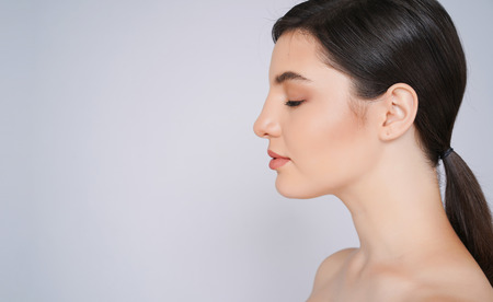 Side view portrait of beautiful with perfect natural skin Portrait. isolated on a light - grey background,with copyspace for slogan or text message.の写真素材