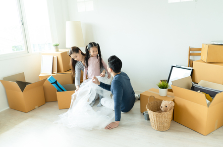 Happy family unpacking cardboard boxes at new home. Moving Concept.の写真素材