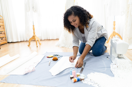 African American fashion designer working on floor in her atelier.の写真素材