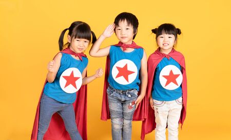 Group of Asian Kids Friendship playing superhero over colorful yellow isolated background.Superheroes and Fun Concept.Happy Time.の写真素材