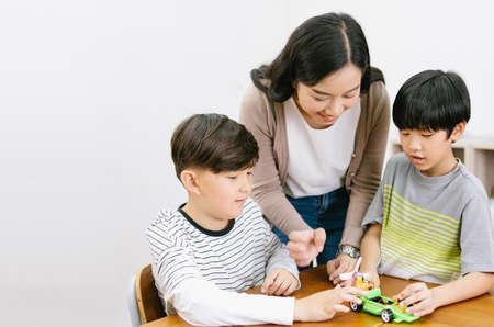 Group of Elementary happy kids and Asian female teacher making electronic toys with colorful in science lesson class. Education, elementary school, learning, science workshop concept. Copy spaceの写真素材