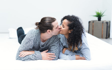Happy couple in love at home.  Romantic young affectionate interracial couple wearing warm sweaters...