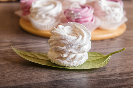 pink and white homemade marshmallows (zephyr) on a round wooden board  on a gray wooden background.の写真素材