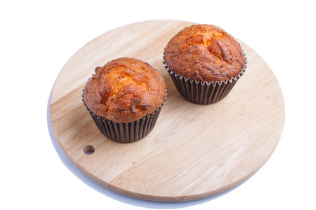 Two carrot muffins  on wooden kitchen board isolated on white