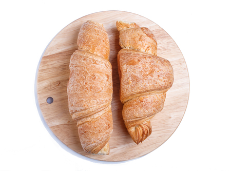 Two croissants on wooden kitchen board isolated on whiteの写真素材