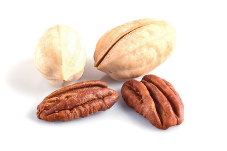 Pile of pecan nuts with shell isolated on white background. close up.
